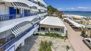 A multi-story hotel with balconies, a covered outdoor seating area, and a view of the beach and sea. - Poseidon Edge No9 by Rentalspro - Kallithea (Kassandra)