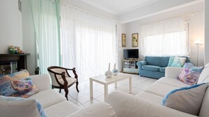 A living room with a sofa, armchairs, a coffee table, and a TV. - Magdalini's Seaview House - Pefkohori (Kassandra)
