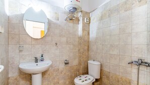 A bathroom with a sink, toilet, and shower.