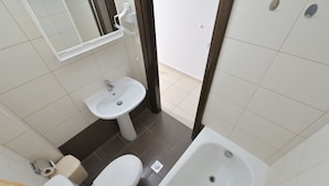 A small bathroom with a toilet, sink, and bathtub. - Tommy Seafront No 1 by Rentalspro - Nea Flogita (Nea Propontida)
