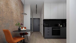 Una cocina moderna con armarios grises, un microondas negro y un horno empotrado.