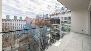 A high-rise apartment with a balcony overlooking a cityscape and a playground. - Stylish Apartment in Wola | Balcony, Parking, Air Conditioning (Warszawa)