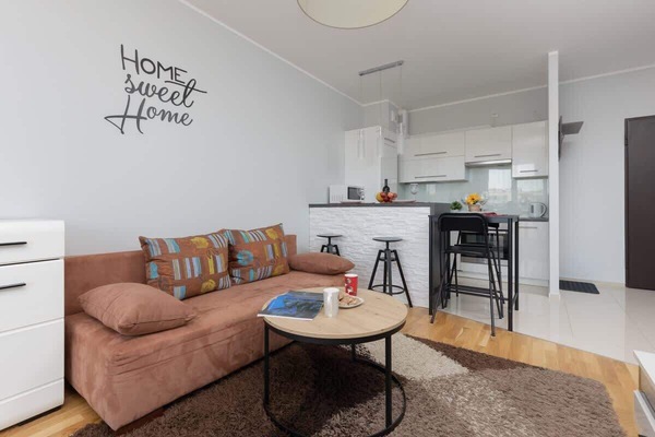Bright living room with corner sofa, round coffee table, and open layout.