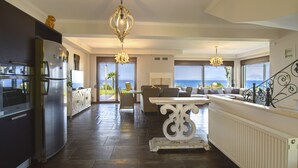 A spacious kitchen with a large island, modern appliances, and a view of the sea.