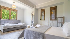 A bedroom with a bed, a sofa bed, a large window, a mirror, and a radiator.
