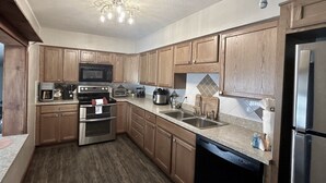 A compact kitchen with wooden cabinets, stainless steel appliances, and a dishwasher.