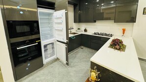 A modern kitchen with a built-in oven, microwave, and a large refrigerator.