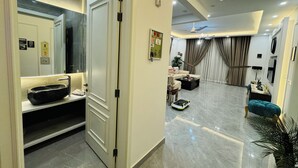 A modern living room with a sofa, coffee table, and a robot vacuum cleaner.