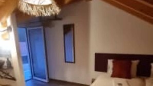Une chambre à coucher comprenant un lit, une table de chevet et une porte donnant sur une autre pièce.