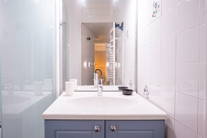 A bathroom with a white sink, a mirror, and a towel rack.