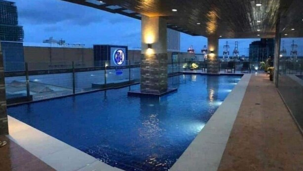 An indoor swimming pool with a view of the city skyline.