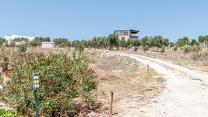 A dirt path leading to a modern two-story building with a flat roof and large windows. - Holiday Home 'Abbacari 1' with Sea View, Wi-Fi and Air Conditioning (Realmonte)