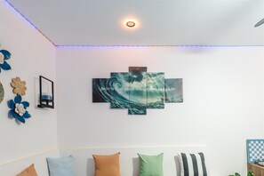 A room with a wall-mounted artwork depicting a sea scene and a ceiling light. - Ocean Dream Apartments E1-A1 (San Juan del Sur)