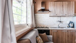 A compact kitchen with a gas stove, wooden cabinets, and a patterned backsplash. - Holiday Home 'Abbacari 2' with Sea View, Wi-Fi and Air Conditioning (Realmonte)