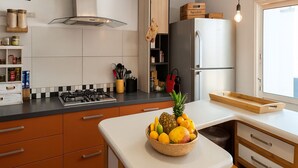 A modern kitchen with a central island, a gas stove, and a refrigerator. - Close to the beach, house with large swimming pool, ideal for family/friends, sea view. (Saint-Paul)