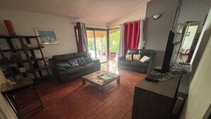 A living room with two sofas, a coffee table, and a bookshelf. - Close to the beach, house with large swimming pool, ideal for family/friends, sea view. (Saint-Paul)