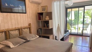 A bedroom with a bed, a bookshelf, and a large window. - Close to the beach, house with large swimming pool, ideal for family/friends, sea view. (Saint-Paul)