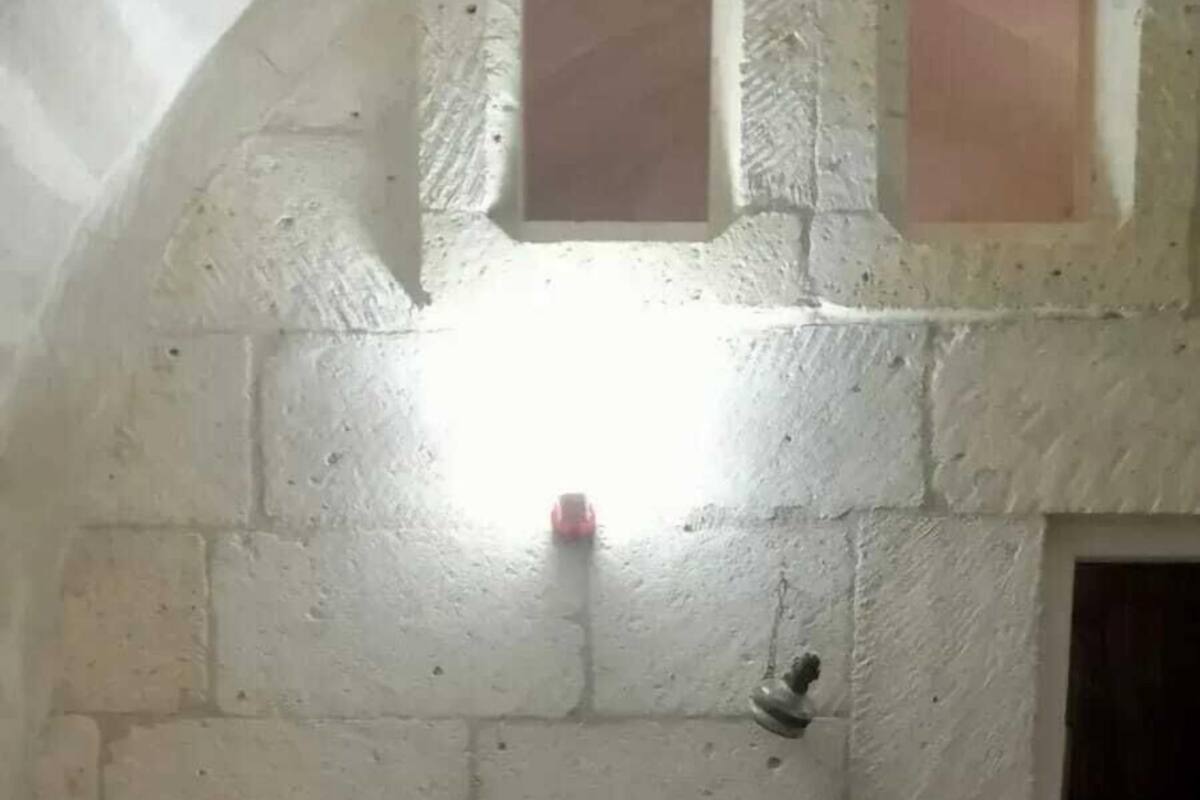 A room with a bed, a small window, and a door.