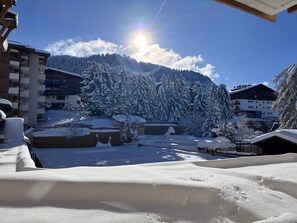 A snow-covered mountain landscape with buildings in the foreground.