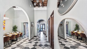 A hallway with checkered flooring, arched doorways, and dining areas with tables and chairs. - Old San Juan Pool House & Jacuzzi Grotto (San Juan)
