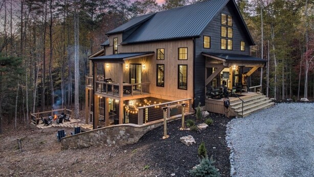 A two-story cabin with a balcony, a fireplace, and a deck area. - Luxury Blue Ridge Cabin • Hot Tub • Sauna • Game Room • 2 Private Acres (Blue Ridge)