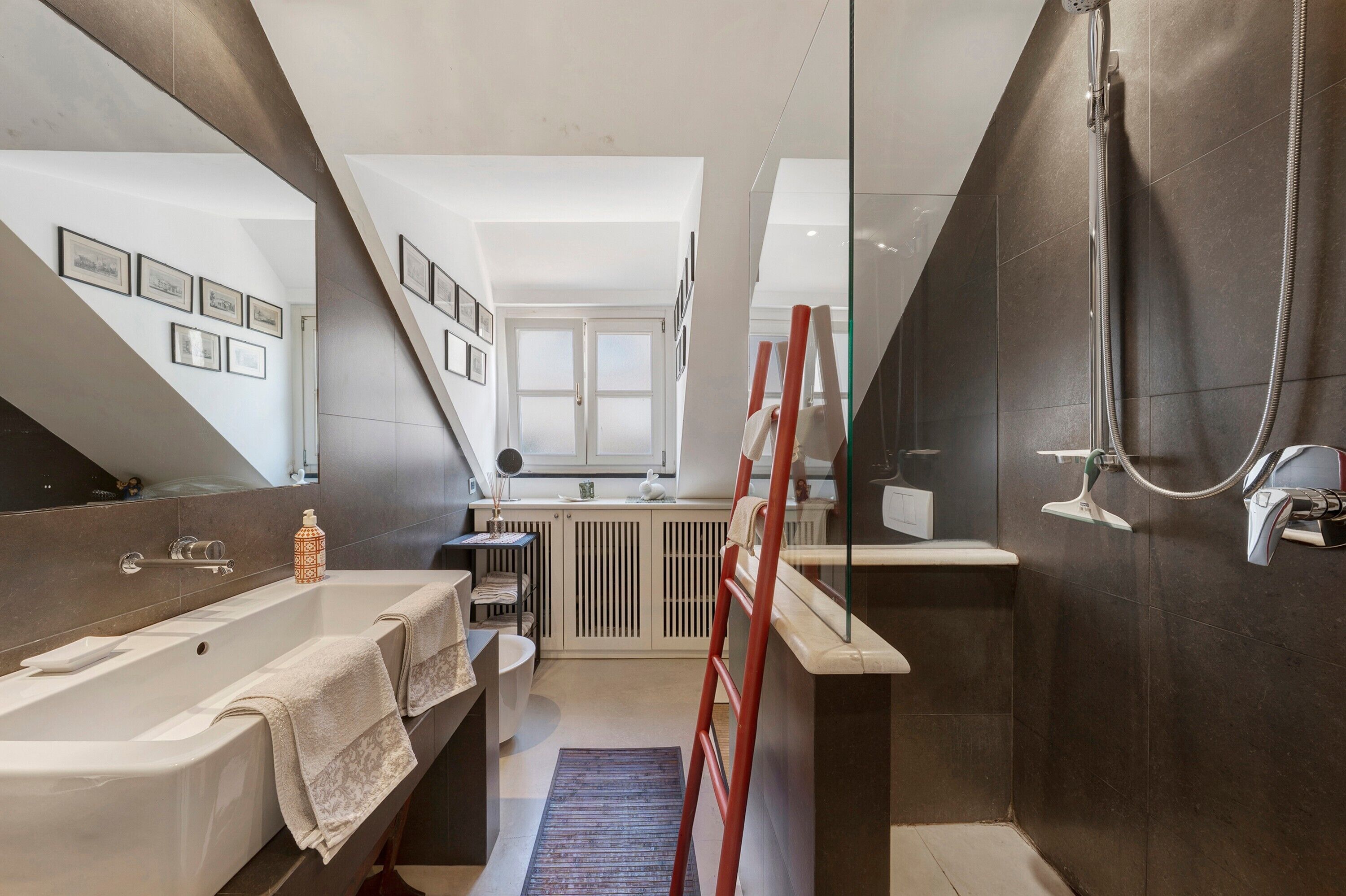 Une salle de bain moderne équipée d’une baignoire, d’une douche et d’un espace de douche séparé par des parois en verre.