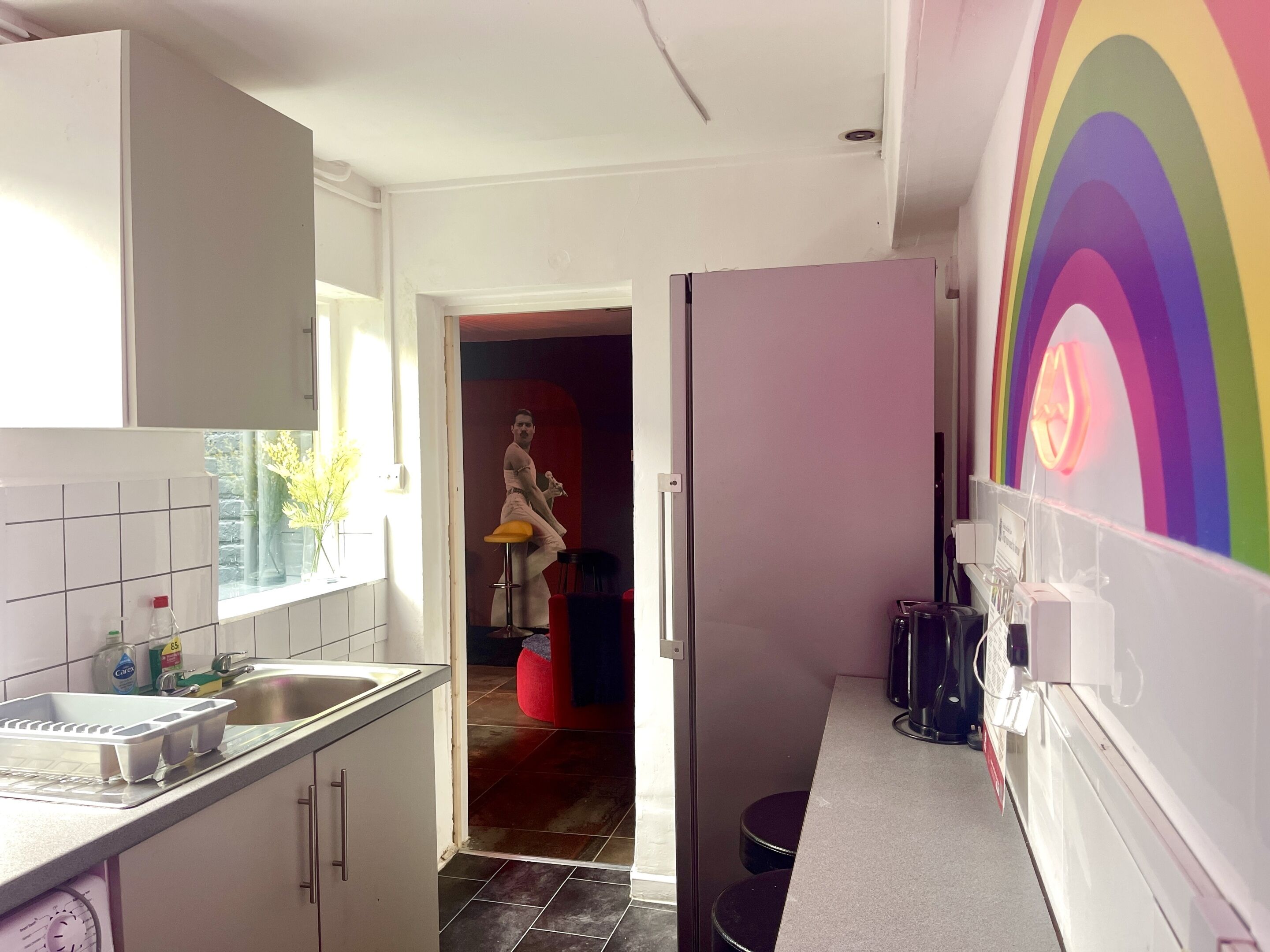A kitchen with a tiled backsplash, a sink, and a refrigerator.