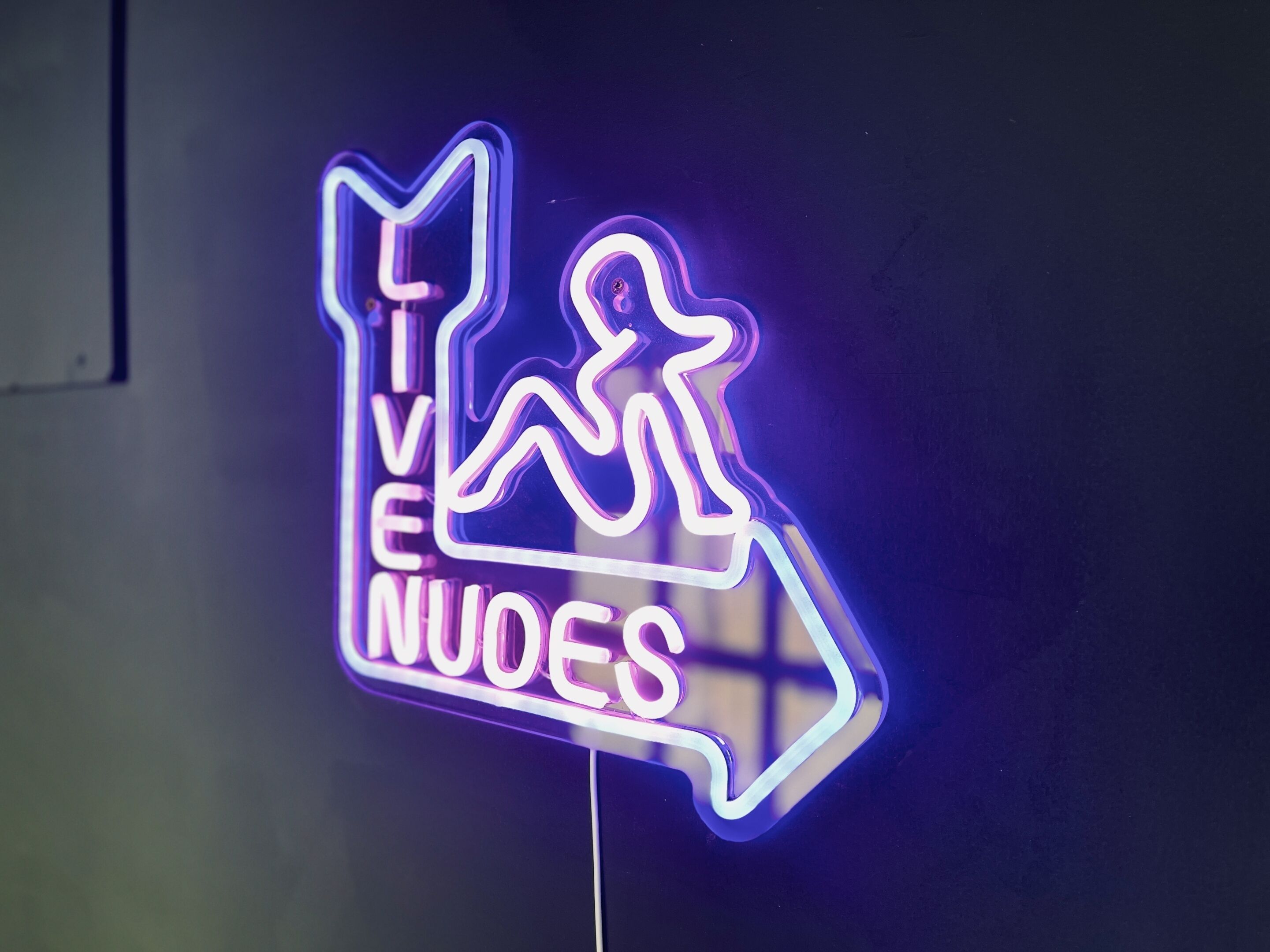 A neon sign with a figure running and the text "LIVE NUOES".