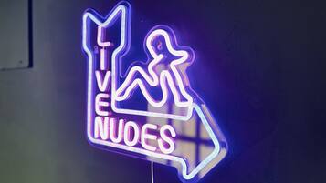 A neon sign with a figure running and the text "LIVE NUOES".