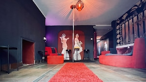 Ein modernes Wohnzimmer mit rotem Teppich, roten Sofas und einem großen Wandbild.