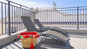 A balcony with a woven basket, metal railings, and a view of buildings. - Holiday Home 'Casa Tita Mercedes' with Private Pool, Wi-Fi and Air Conditioning (Nerja)