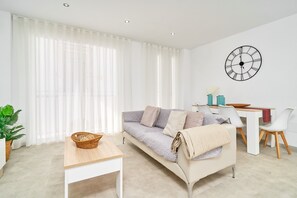 Uma sala de estar moderna com um sofá, uma mesa de jantar e um relógio de parede.