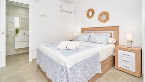A bedroom with a bed, bedside table, and a nightstand with a lamp. - Holiday Home 'Casa Tita Mercedes' with Private Pool, Wi-Fi and Air Conditioning (Nerja)