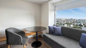 A modern living room with a grey sofa, a round table, and a chair. - Fairfield By Marriott Jaipur Tonk Road (Jaipur)
