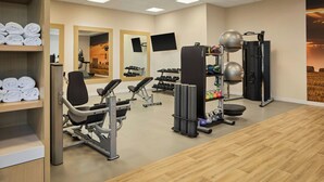 A gym with exercise equipment, a mirror, and a wall-mounted TV. - Fairfield by Marriott Inn & Suites Perry (Perry)