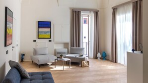 Ein geräumiger Wohnbereich mit einem modernen Sofa, einem Esstisch und einer Küchenzeile.