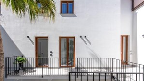 Ein weißes Gebäude mit Balkon, Holztür und Fenster.