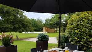 An outdoor dining area with a table set for two, surrounded by chairs, under a large umbrella. - 'Fuchia' Guest Room with Shared Pool, Terrace, and Wi-Fi (Beaumont sur Grosne)