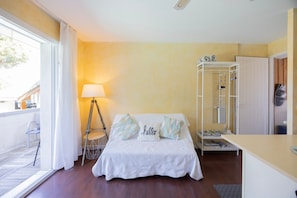 Ein Schlafzimmer mit Bett, Lampe, Kleiderschrank und einem kleinen Tisch.
