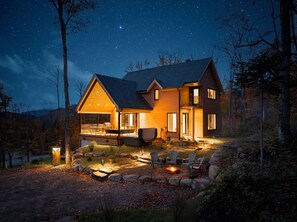 Uma cabana com varanda, área de estar externa e lareira.