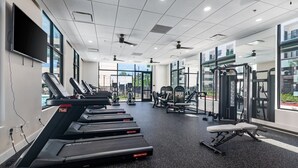Una palestra moderna con tapis roulant, macchinari per pesi e una panca.