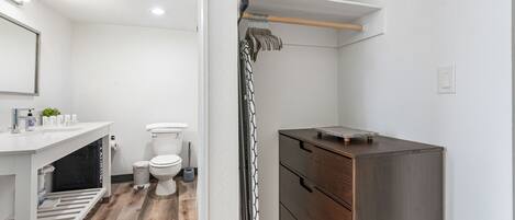 Un bany modern amb un lavabo, vàter i moble de tocador de fusta.
