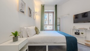 Une chambre à coucher moderne avec un lit, une table de chevet et un téléviseur fixé au mur.