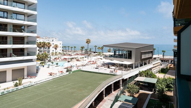 A resort with a pool, outdoor seating, and a view of the sea. - MalagaSuite Sky & Sea Torremolinos (Torremolinos)