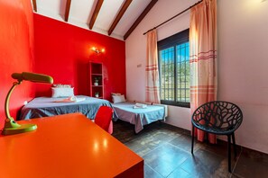 A room with two beds, a desk, a chair, a red wall, a window with curtains, and a wooden ceiling. - MalagaSuite Villa Rural Madeira (Algarrobo)