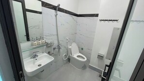 Standaard tweepersoonskamer | Badkamer | Een douche, een haardroger, handdoeken, zeep