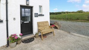 Un bâtiment blanc avec une porte noire, un banc à l’extérieur et une enseigne indiquant « Coach House ».