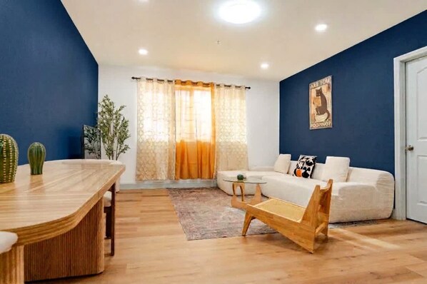 A modern living room with a sofa, a coffee table, and a dining table.