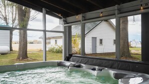 A hot tub under a covered area with a view of houses and trees. - Pinch of Cozy ~ Hot Tub Theater ~ Seven Sons Farm (Roanoke)