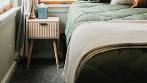 A bedroom with a bed, a nightstand, a window with curtains, and a map on the wall. - Pinch of Cozy ~ Hot Tub Theater ~ Seven Sons Farm (Roanoke)